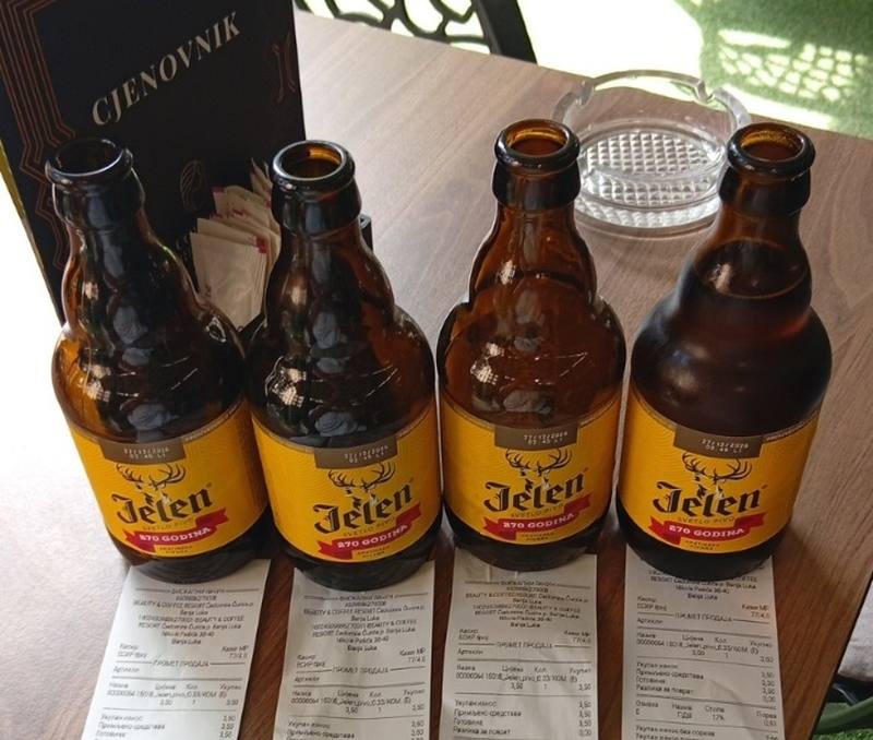 Four bottles of Jelen beer with their fiscal receipts on a table in Banja Luka, each showing 3.50 KM