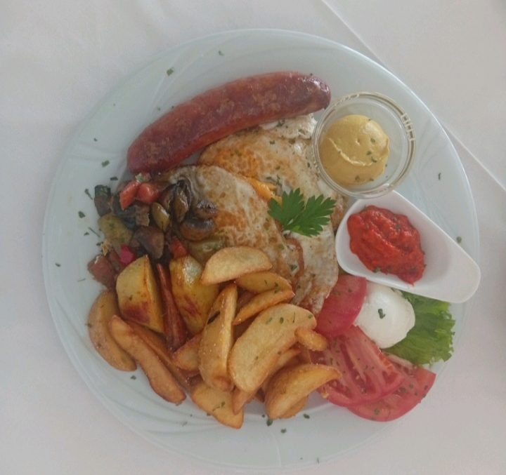 Bosnian breakfast — kobasica, fried egg, roasted potatoes, ajvar