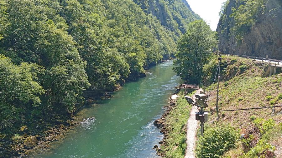 View down into the Vrbas canyon with the green river between forested slopes